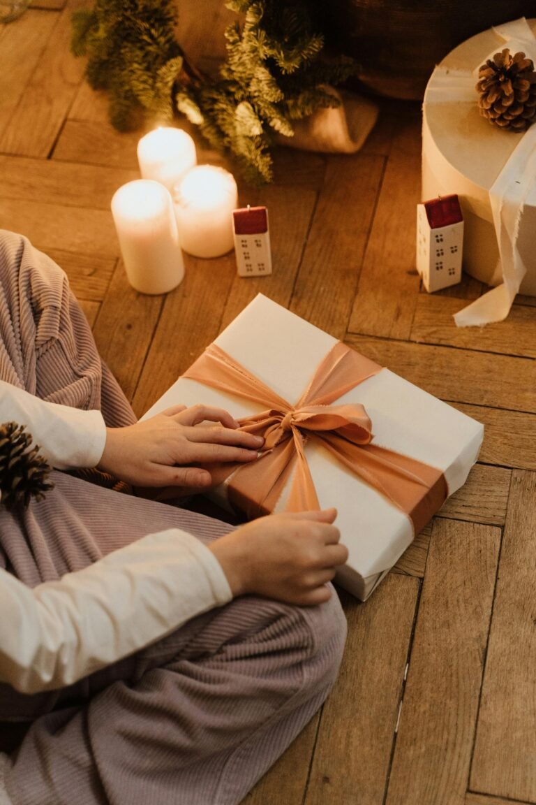 Warm indoor scene with a person preparing Christmas gifts and candles.